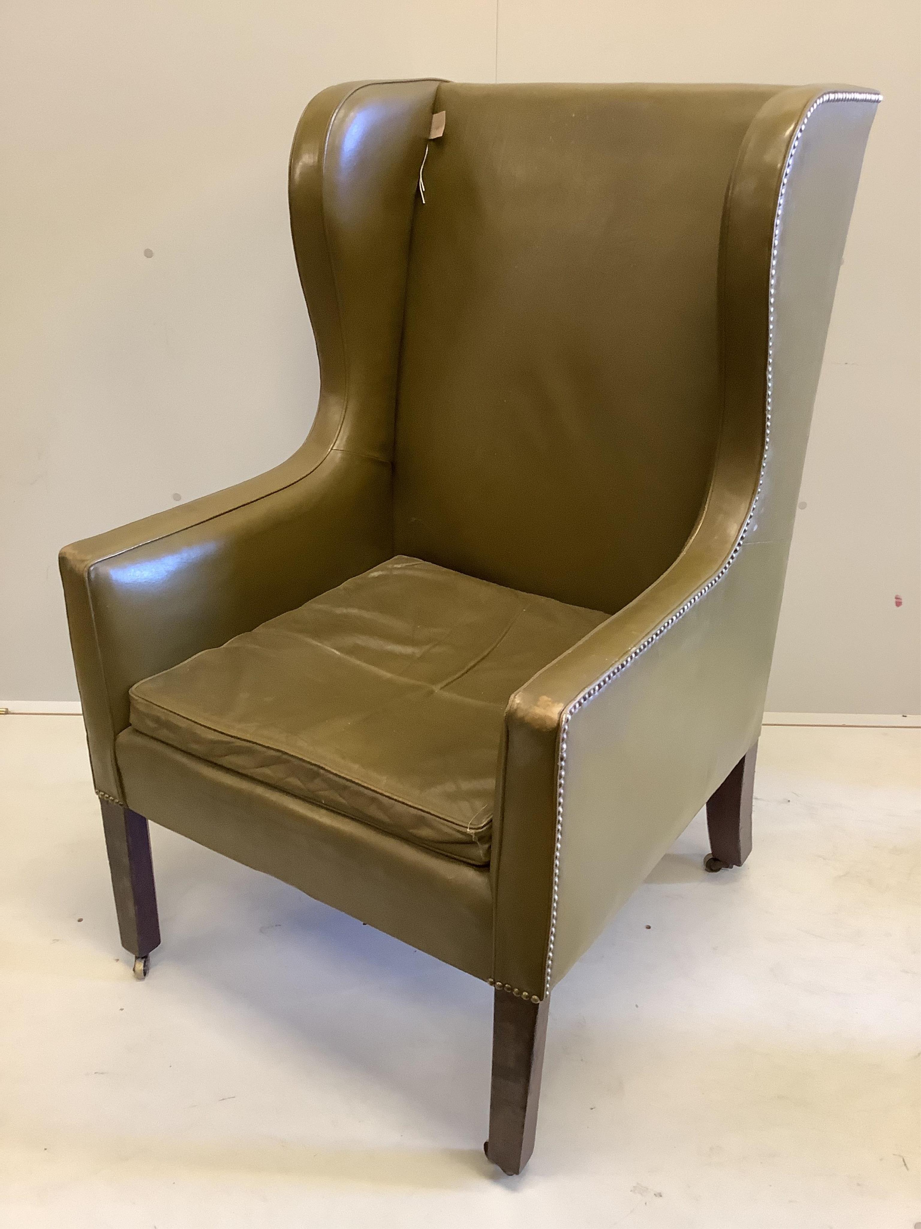A George III wing armchair with olive leather upholstery, width 70cm, depth 70cm, height 115cm. Condition - fair